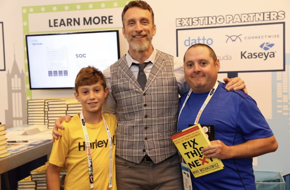 Our CEO Darryl Cresswell and his son pose for a picture with business improvement author Mike Michalowicz